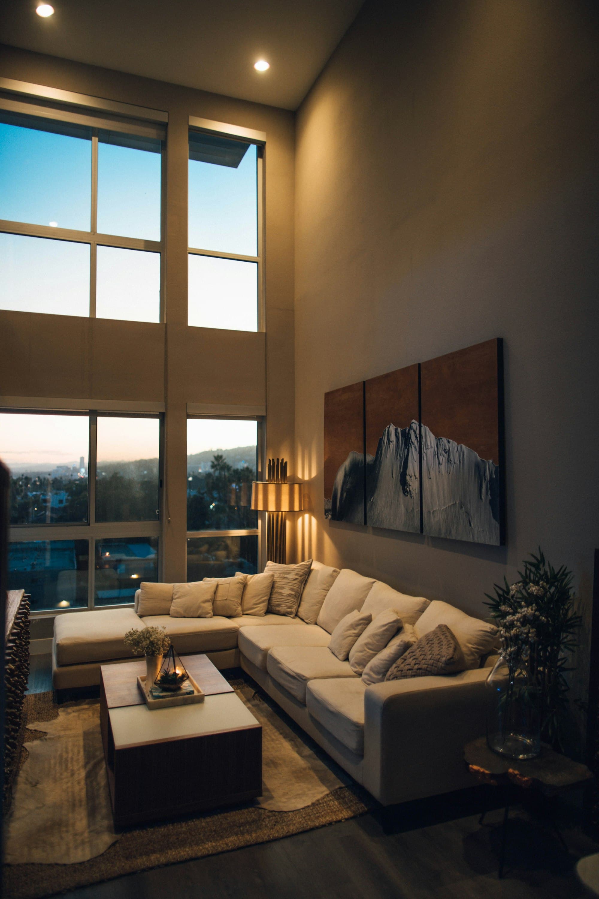 Modern city apartment living room with skyline view at dusk